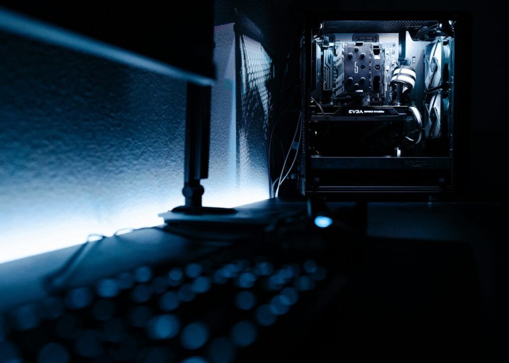 Dark, atmospheric shot of a high-end gaming PC setup in a minimalist room.