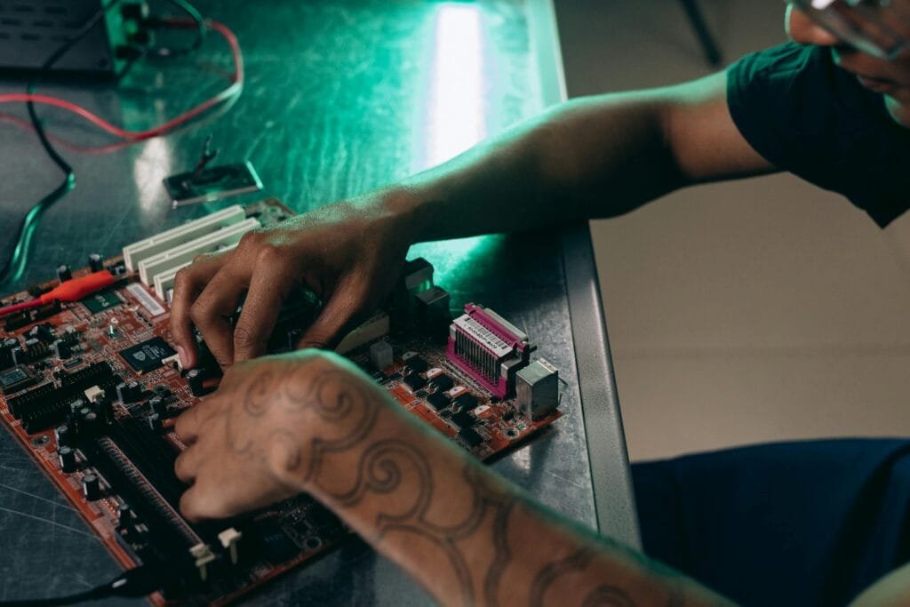 Close-up of person assembling a computer motherboard, showcasing a tattooed arm and tech innovation.