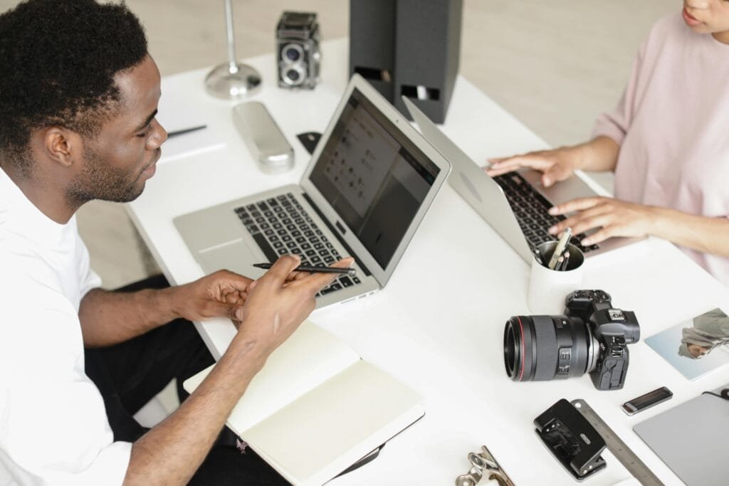 Photographers collaborating in a modern workspace with cameras and laptops.