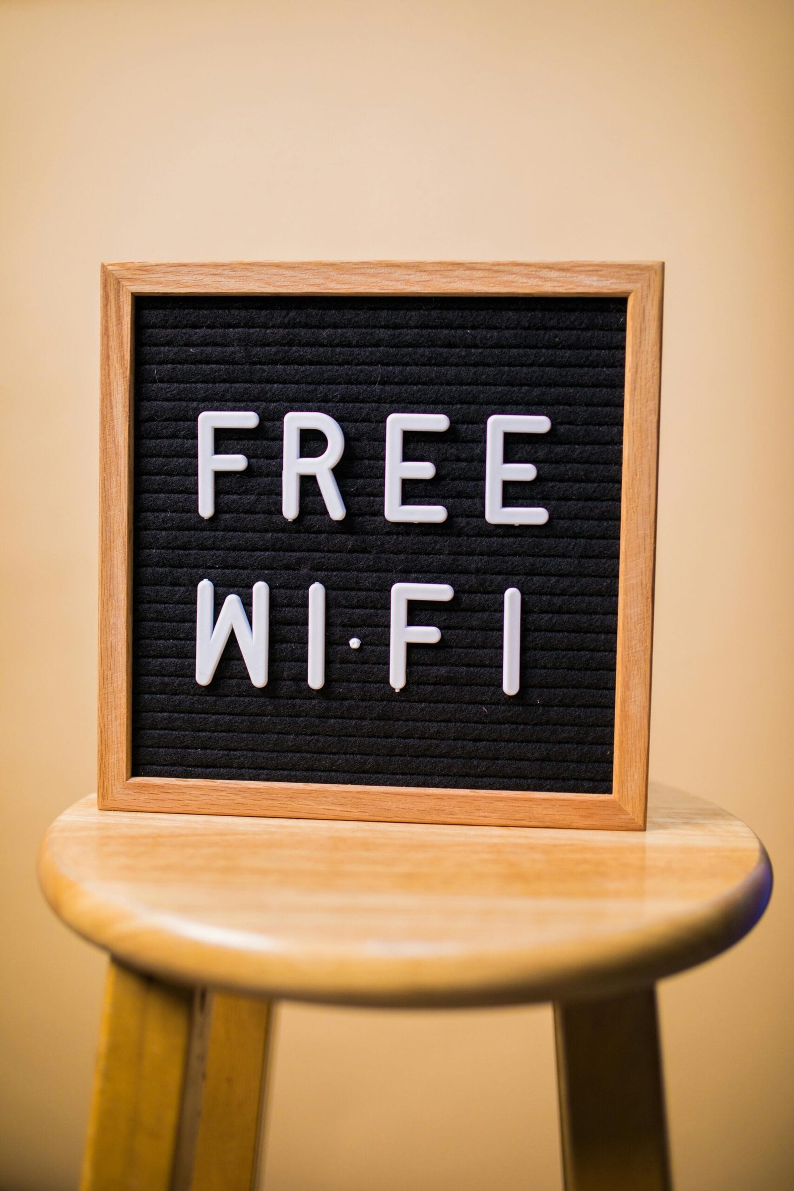 Letterboard displaying 'Free Wi-Fi' on a wooden stool in an indoor setting.